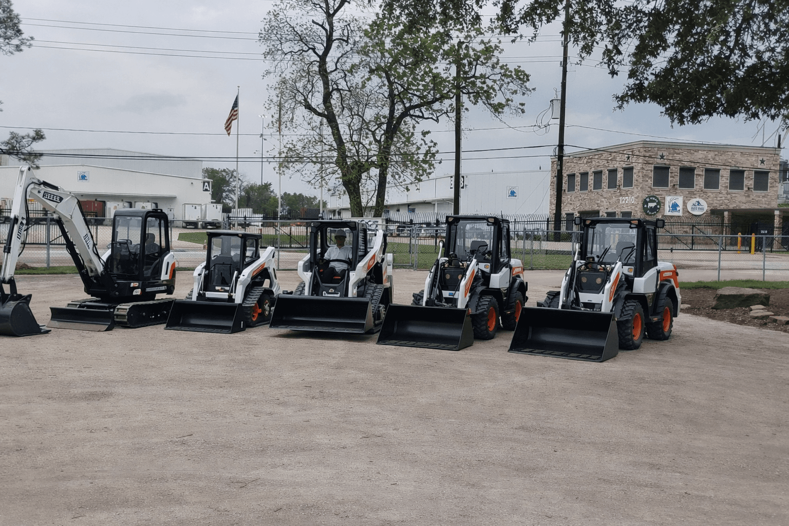 Bobcat rental fleet lined up outside the Houston facility with compact track loaders and an excavator ready for pickup or delivery.