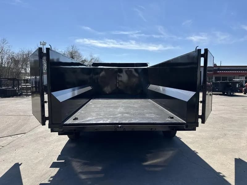Rear view of the 16 foot dump trailer with the back doors open to show bed access and loading width.