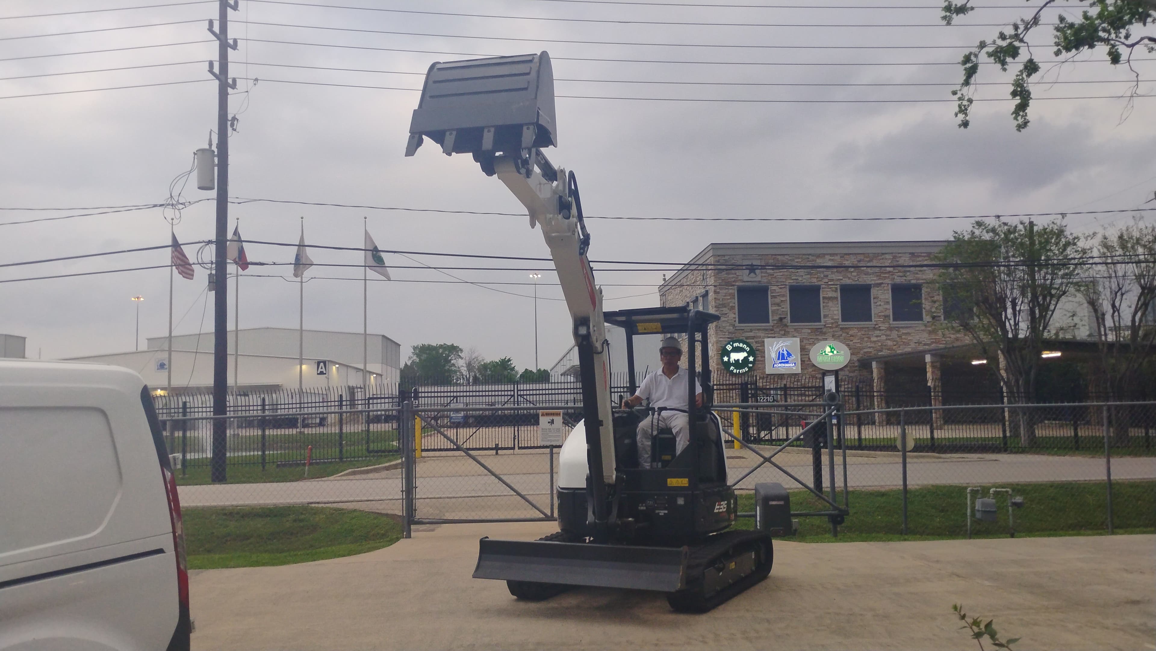Bobcat E35 compact excavator in Houston with the bucket lifted overhead to show boom height and vertical reach.